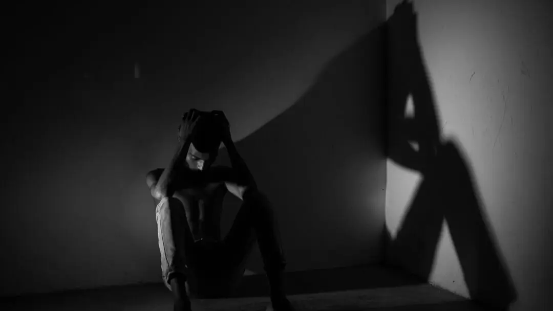 depressieve man in kamer denkt na over zelfdoding